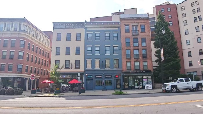 A line of buildings in Albany. In the center is our office in Albany: a navy blue building (4 stories). 