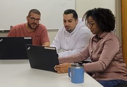 Two male and one female employee of New York Registered Agent LLC work on laptops in the Albany office.
