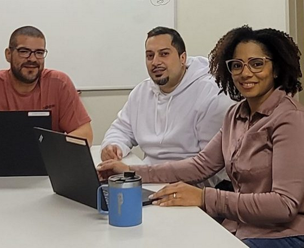 Three people collaborate on a project at a table