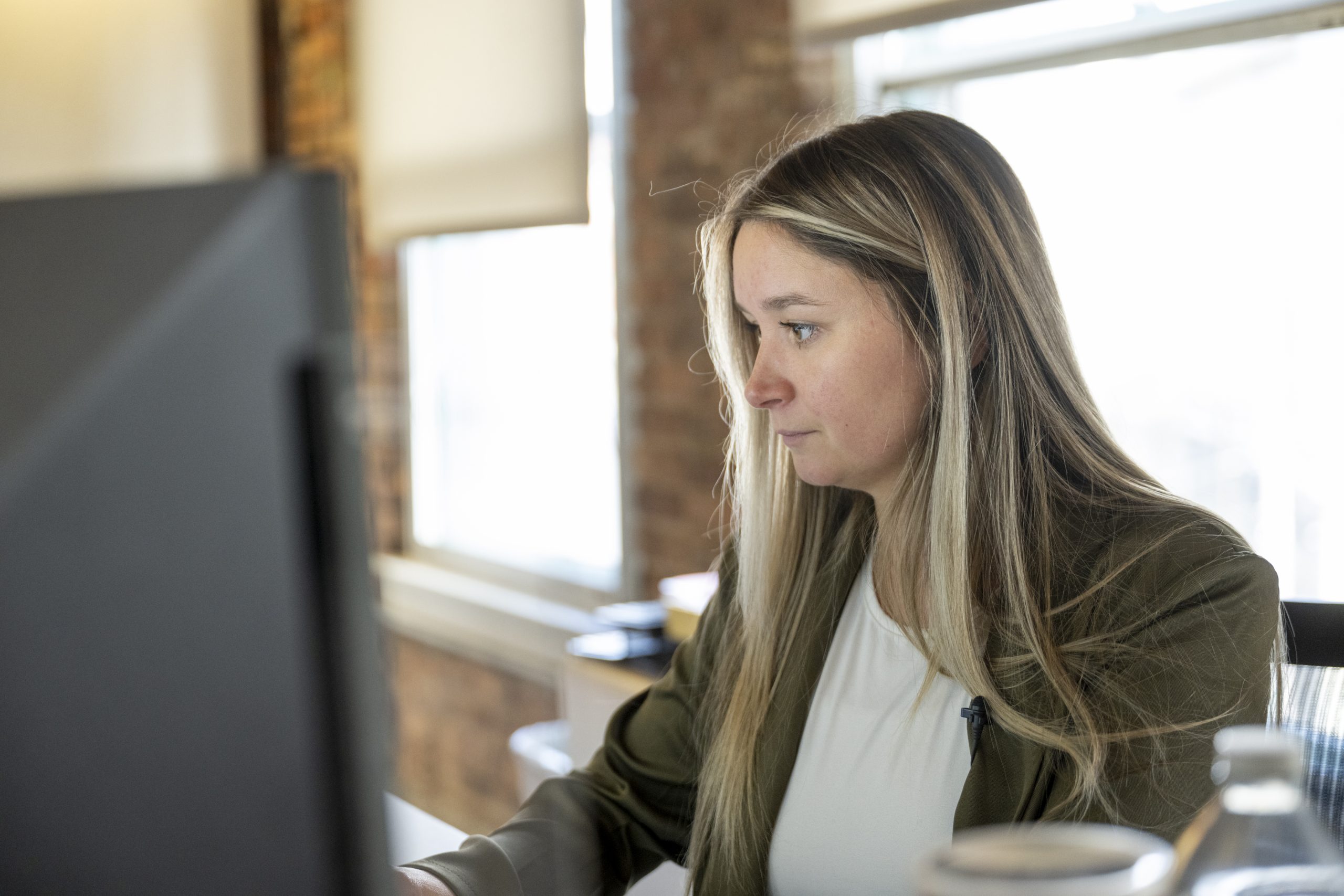 A woman stares at a computer screen inside the offices of New York Registered Agent.