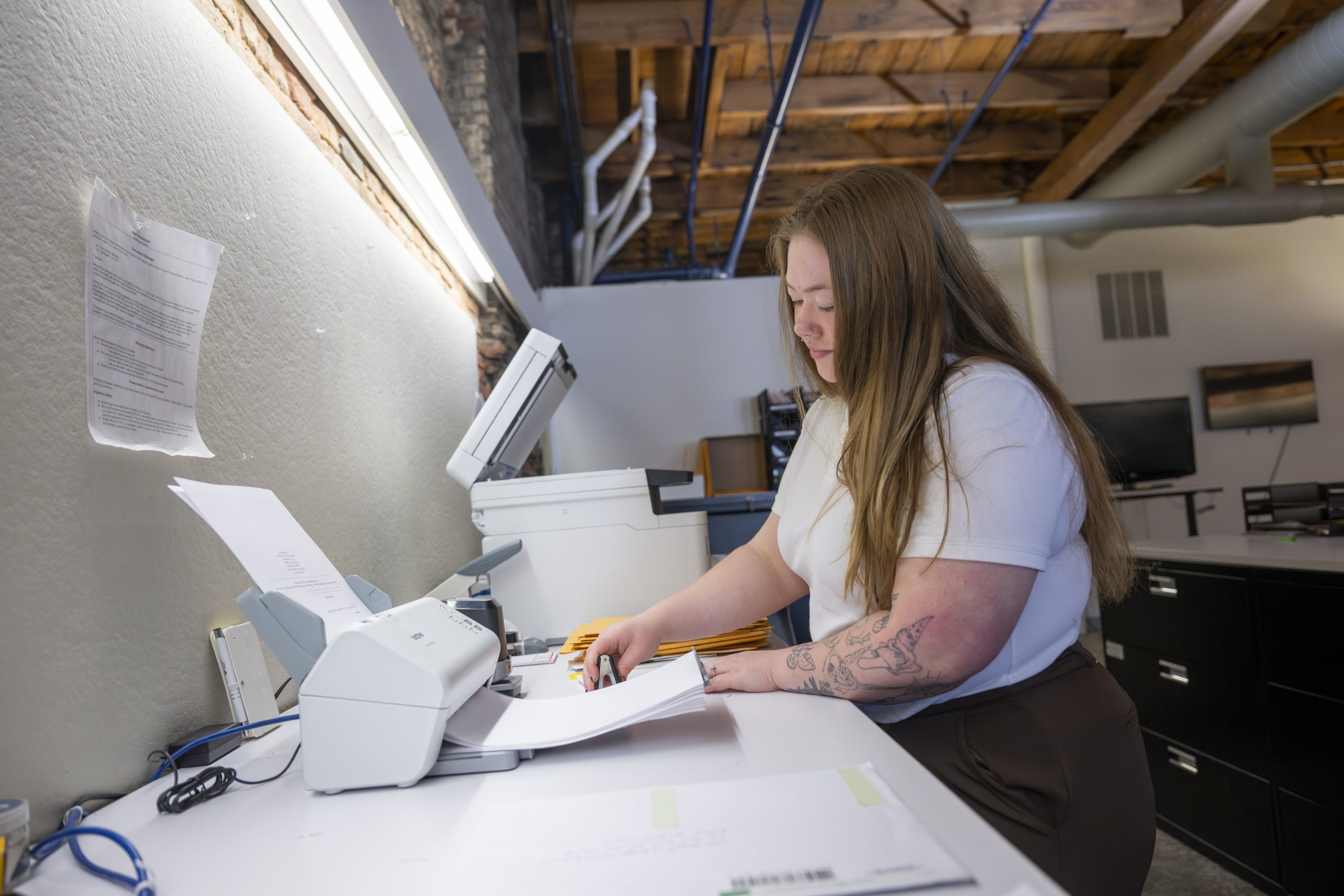 An employee of New York Registered Agent feeds papers into a fax machine.